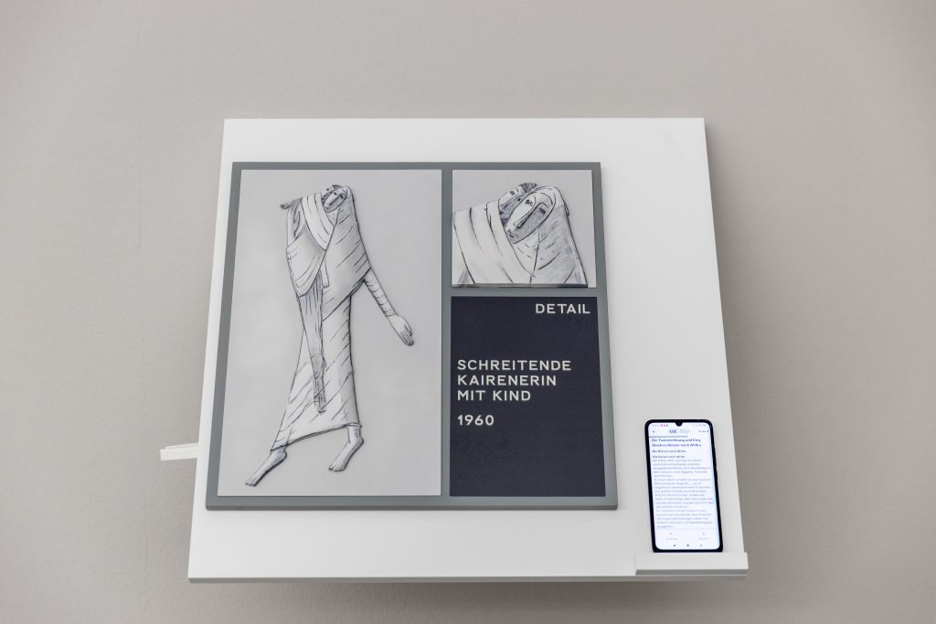 Eine Station in einem Ausstellungsraum mit tastbarem Relief des Kunstwerks "Schreitende Kairierin mit Kind von 1960".